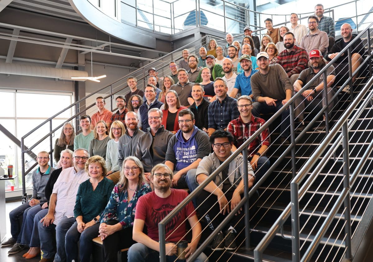 A group photo of the entire Elite EXTRA team in the stadium of their headquarters building in Eau Claire, WI